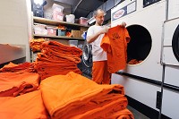 Mike Tuttle, an inmate at the Hancock County Jail, sorts through freshly dried clothes while doing laundry Tuesday. Staff photo by Tom Russo