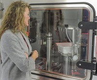 Singote CEO Alisa Wright stands in front of the new Varnx Pharmasystems SA25 robotic work-cell which is self-contained, sterile environment in which robots fill vials, cartridges and syringes with medicine. Staff photo by Kurt Christian