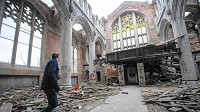 Associate city planner and Amercorps vista worker Sam Salvesen takes photos with his phone recently in the sanctuary of the abandoned City Methodist Church in Gary. (Kyle Telechan / Post-Tribune)