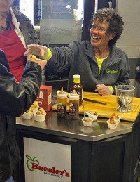 Connie Huff of Baesler's stopped customers on their way into the market Monday to make sure they got a sample of Hoosier-grown food products. Staff photo by Austen Leake