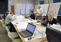 A consulting team from Rundell Ernstberger Associates is hard aa work Wednesday with Zionsville Parks &amp; Recreation Superintendent Matt Dickey (standing) creating design concepts for Overley-Worman Park. Staff photo by Andrea McCann