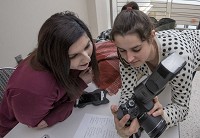 Editor Alicia Flores, an IUSB senior, left, and reporter Kendall Asbell, also a senior, look at photos on te back of Asbell's camera, Thursday, April 6, 2017, in South Bend. Staff photo by Becky Malewitz