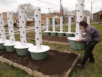 Austin Kasso sets up garden towers Monday, April 3, 2017, in a lot near Wabash Avenue and Ellsworth streets in Lafayette. Kasso will grow a variety of vegetables in 12 garden towers. He plans to give 30 percent of what he grows away for free. The remaining 70 percent will be sold through City Foods and in local farmers markets. Staff photo by John Terhune