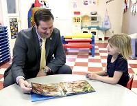 Mayor Matt Gentry sits with one of the childen at Little Angels LLC and reads a book Tuesday morning. Photo courtesy of Boone EDC