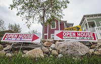 For sale and open house signs sit outside a home on North St. Louis Boulevard in South Bend on Friday. Staff photo by Robert Franklin