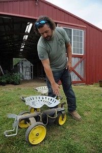 Jonathan Lawler looks at one of the special carts available for seniors to use while harvesting fruits and vegetables at the Brandywine Creek Farms in Hancock County. Staff photo by Tom Russo
