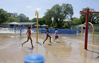 Nina Garner, Rianna Anderson and Trinity Moore, all 10-year-olds from Merrillville, run through the Wicker Memorial Park splash pad n Highland during opening day on Saturday. Staff photo by Suzanne Tennant