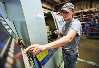 Cutting Edge Machine and Tool employee Kellie Anglemyer of Goshen punches commands into the CNC machine she operates to make pins for wheelchair lifts Thursday morning. CNHI staff photo by Jay Young