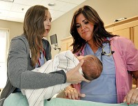 Community Hospital Anderson registered nurses Savannah Cooper nad Erin Baledge take care of a newborn in the New Generations Birth Place in the hospital. Staff photo by John P. Cleary