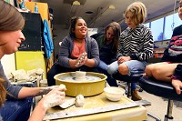 After getting her hands dirty during art class, Izzy Loer jokes with the other New Leaf Mentoring students and mentors. Staff photo by Tim Bath