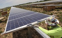 Patrick Bonar installs a solar panel in an 8-1/2-acre field Wednesday afternoon, south of Mitchell. The solar array will produce 2 million kw/h for the electricity grid supplying Orange County REMC with enough alternate, renewable energy to power 150 homes. Staff photo by Rich Janzaruk
