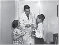 In this file photo from the Indiana University School of Dentistry, Dr. Joseph C. Muhler presents toothpaste and tooth brushes to two of the 12,000 young volunteers who took part in tests of a stannous fluoride toothpaste.