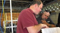 Dan Boyd, left, environmental health specialist with the Porter County Health Department, goes over Indiana Code with Bill Helton of Green Frog on Wednesday at Seven Peaks Water Park Duneland. Green Frog was hired to bring the water park back into compliance so it can reopen. (Amy Lavalley / Post-Tribune)
