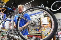 Zac See, owner of Breakaway Bike shop in Peru, works on bikes that were found by the police and not claimed. The bicycles are then given to those who need transportation through Life Cycle, the first program of its kind in the state. Staff photo by Tim Bath