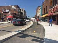 A bicyclist and cars go down State Street in Chauncey Village on Monday, Aug. 14, 2017. The stretch of State Street from Salisbury Street to North University Street, including the new bike path, reopened Monday. Staff photo by Meghan Holden