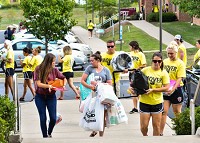 Freshman Tori Cowell, left, and sister Sarah Baker, center, aare helped by fraternity and sorority member as they carry belongings to her Grove Lodge form on the IU Southeast campus Aug. 17, 2017. Staff photo by Tyler Smith