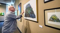 John Cain, executive director of South Shore Arts, points out details in a work by artist Terry Lacy in the gallery at South Shore Arts' Munster location on Friday, Aug. 25, 2017. (Kyle Telechan/Post-Tribune)