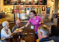 Waitress Madison Goffinet brings an order to Gayle Hagemeier and family during her shift at Cricket's Cafe in Sellersburg on Friday afternoon. Staff photo by Tyler Stewart