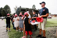 JFD Sgt. Justin Ames hands out plastic firefighters helmets to Spring Hill Elementary students during a community event in July 2017. Staff photo by Josh Hicks
