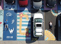 Nick Conner, left, and Sydney Beane are among about 50 students who have painted their individual parking spots at Elkhart Central High School. Staff photo by Santiago Flores