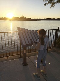Gracie Varnak tries the "Yantzee" xylophone at Unity Park overlooking Pine Lake in La Porte, one of five musical sculptures being installed around the city. The photo was taken by Unity Foundation vice president Deb Varnak.&nbsp; Submitted photo