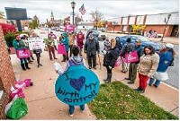 Casie Farnsworth, of South Bend, wears a costume that reads &ldquo;I love my birth control&rdquo; as she speaks to a crowd of protesters outside Rep. Jackie Walorski&rsquo;s office Thursday in Mishawaka. Tribune Photo/ROBERT FRANKLIN