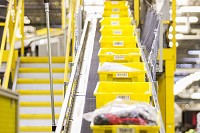 Yellow totes containing various items are pictured on an automated sorter during the outbound process during Cyber Monday at the Amazon Fulfillment Center in Jeffersonville on Monday. Staff photo by Josh Hicks
