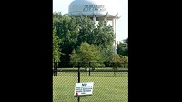 The water tower overlooking an unused ballfield at Carrie Gosch Elementary School says &ldquo;for our children,&rdquo; but a sign from the EPA warns in Spanish that people shouldn&rsquo;t play in the dirt or mulch. (Joe Puchek / Post-Tribune)