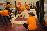 Volunteers from Amazon assemble one of the built 54 beds constructed on Saturday. Staff photo by Jenna Esarey