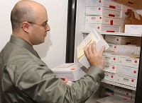 In this 2001 file photo, Det. Steven Metcalfe looks over a collection of rape kits kept in locked storage at the St. Joseph County Police Department. Tribune File Photo