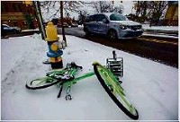A LimeBike lies in the snow along Niles Avenue Friday in South Bend. A company spokesman Friday reiterated LimeBike&rsquo;s plans to keep the bikes outside all winter. Tribune Photo/ROBERT FRANKLIN