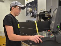 High-tech: Will Edington punches in commands on a machine on Wednesday morning at Starke Industries in Terre Haute. Staff photo by Asten Leake