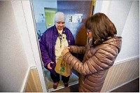 Meals on Wheels volunteer Sig Phillipoff delivers lunch to Paula Spart recently at her South Bend apartment. Spart is grateful for the service, which is helping her live independently despite a disability. Tribune Photo/MICHAEL CATERINA