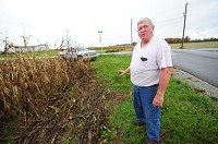 Ronnie Mohr of Greenfield stands near the intersection of county roads 500E and 700N, showing how he and his team cut their crops when planting so close to the road. Mohr, whose brother was involved in a bad crash that was blamed on poor visibility because of high corn, wants to see farmers take more responsibility in keeping local roads safe. Staff photo by Tom Russo