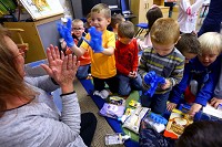 Cheryl Graham of the United Way of Howard County brings school supplies to Becky Schmidt's Western Primary School kindergarten class Jan. 8, 2018. Ethan Alderfer tries on the rubber gloves that were donated along with various other sensory items. | Tim Bath, Kokomo Tribune