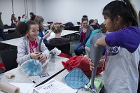 Girl Scout Troop 3394 members Stephanie McIntosh, left, and Karinna Kenner work on creating prosthetic legs from recycled materials Saturday at Ivy Tech Community College during Wow! That&rsquo;s Engineering!, an event sponsored by Cook Medical and the Society of Women Engineers. The event aims to encourage young girls to think of engineering as a future career option. Staff photo by Jonathan Street
