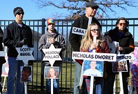 Lilia Wolf hlds a cross bearing the name and photo of Nicholas Dworet, one of the 17 people killed Feb. 14 in the Parkland, Florida, mass school shooting, during a protest Saturday outside the Lake County Fairgrounds in Crown Point. Staff photo by Kale Wilk