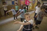 Andrea Burnet moves to music Friday in the preschool at Holy Cross School in South Bend that&rsquo;s part of the state&rsquo;s On My Way Pre-K program. Tribune Photo/SANTIAGO FLORES