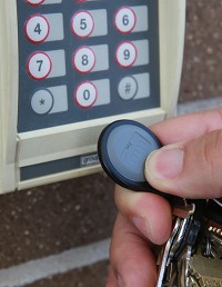 School Resource Officer Dion Campbell demostrates how a key fob works at the entrance to Michigan City High School. Staff photo by John J. Watkins