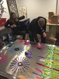 Local artist Stillson and his daughter, Cybil, work to create a toothbrush sculpture for the Flower Garden in downtown Nappanee