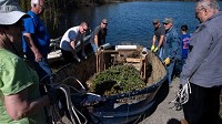A group of volunteers prepares to launch a boat filled with assorted objects with the intention of sinking it to create fish habitat on Saturday, May 5, 2018 at the Izaak Walton League in Griffith. (Michael Gard / Post-Tribune)