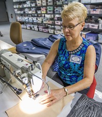 Theresa Luczek works on an industrial sewing machine at Sew Loved in South Bend during Tuesday&rsquo;s open house. Staff photo by Robert Franklin