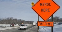 A sign in an I-69 construction area north of Bloomington calls for traffic to use both lanes and take turns at the merge point as the road narrows from one lane to two. The &ldquo;zipper merge&rdquo; method keeps traffic flowing better, but can be hard for motorists to get used to. Staff file photo by David Snodgrass