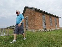 Lynn Cason walks back to his van after a visit to the old Morris School, District No. 5 Wabash Township, Friday, September 23, 2016, at Cumberland Avenue and U.S. 231 in West Lafayette. After the one-room schoolhouse closed, Cason said farmers stored grain in the building. The school, built in 1879, sits on property Cason sold to Franciscan Health. Cason is working with the City of West Lafayette and others to move the schoolhouse about a quarter mile east to land he is donating for a new city park&nbsp; Staff photo by John Terhune