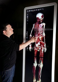 Ivy Tech Program of Science Chair Leo Studach demonstraaes and Anatomage table, a new piece of teaching technology thaat displays the anatomy in detail through all layers of the body. Staff photo by Tim Bath