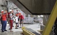 Tony Rizzo, riht, and his grandson, Maksim Knott, watch limestone being cut at Indiana Limestone Co. Wednesday. A limestone tour, hosted by Lawrence County Tourism, was scheduled to celebrate the area's rich limestone history. Staff photo by Rich Janzaruk