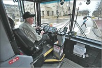 Bloomington Transit bus driver Leslie Hart drives his route Monday on the near east side and around the Indiana University campus in Bloomington. TOP: Hart keeps an eye on traffic Monday on his Bloomington Transit route. The local transit system is faring better than those in many Indiana communities, but ridership is down. Staff photo by Chris Howell