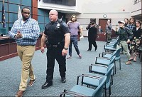 Bloomington Police Department Capt. Scott Oldham escorts Vauhxx Booker, of Bloomington Black Lives Matter, from the council chambers Wednesday after he interrupted a Bloomington City Council meeting to talk about the city&rsquo;s purchase of an armored personnel carrier for the Bloomington Police Department. Staff photo by Jeremy Hogan