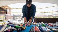 Artist Christopher Olszewski arranges paint on a table on the opening day of his installation near Valparaiso's Urschel Pavilion on Thursday, April 26, 2018. (Kyle Telechan / Post Tribune)