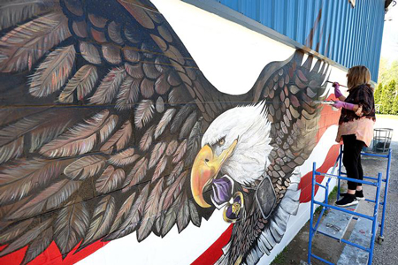 Rhonda Eads paints a mural dedicated to Pfc. Carl Hughes Jr. at Northside Park on May 9, 2023. Tim Bath | Kokomo Tribune